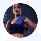 Woman wearing a sports bra with a blue towel over her shoulder.