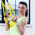 Woman exercising with resistance bands wearing pink gloves.