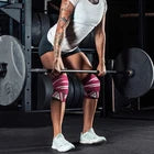 Person performing deadlift wearing pink knee wraps
