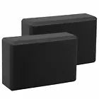Two black foam yoga blocks on a white background
