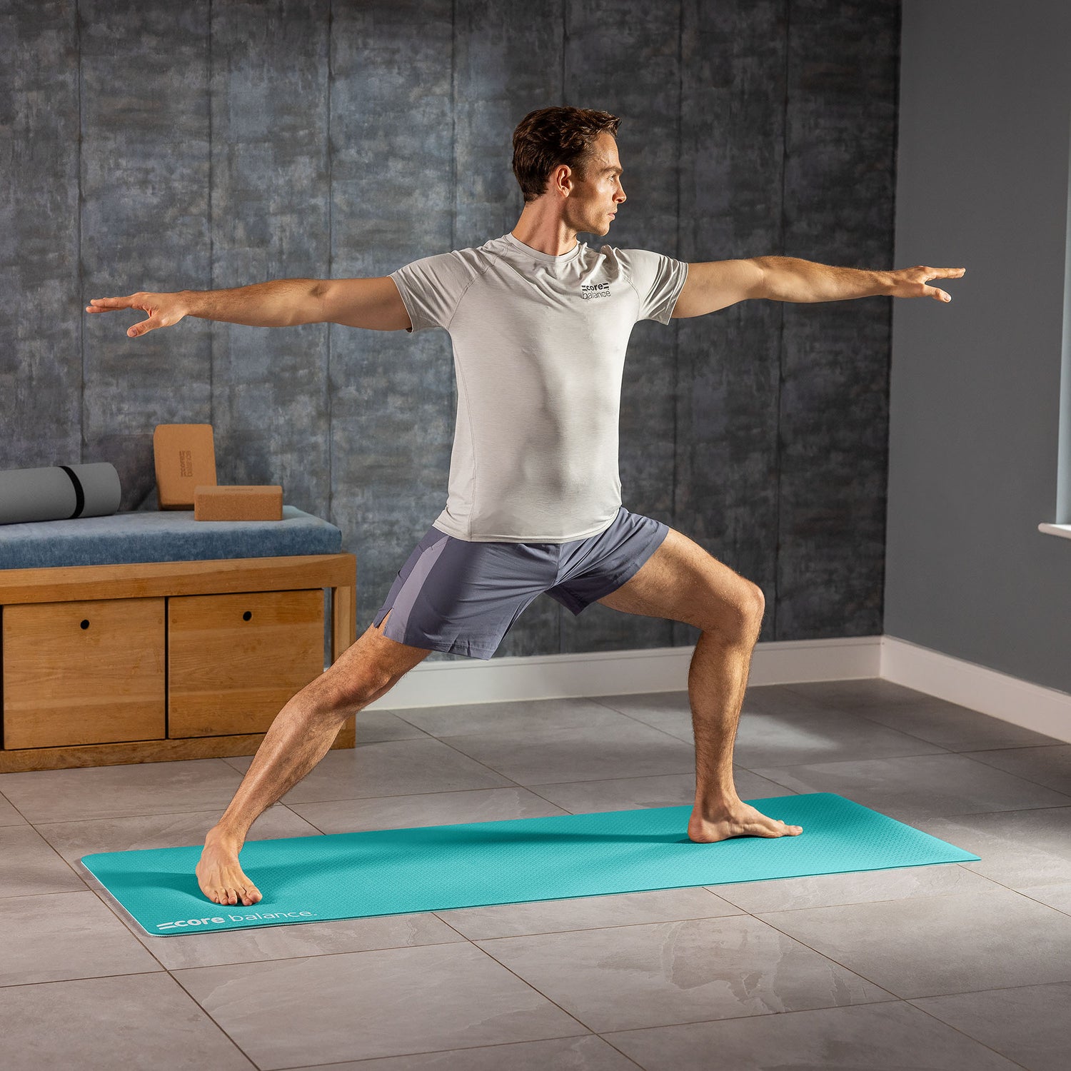 Man practicing yoga in a home setting on a green yoga mat.